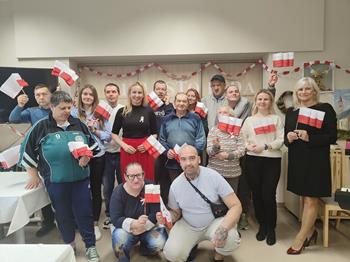 Uczestnicy oraz kadra ŚDS w Gryfinie machają biało czerwonymi flagami
